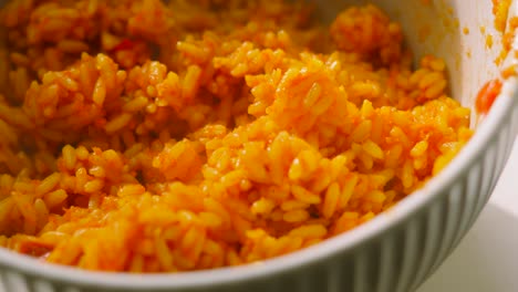bowl of freshly cooked mexican style rice with spices and vegetables with hot steam rising. high carb side dish