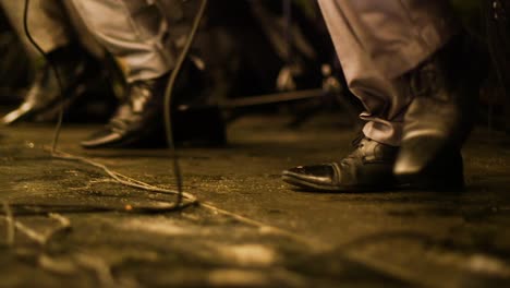 Toma-En-ángulo-Bajo-De-Los-Pies-De-Los-Miembros-De-La-Banda-Bailando-Juntos-En-Sincronización-Durante-Una-Actuación