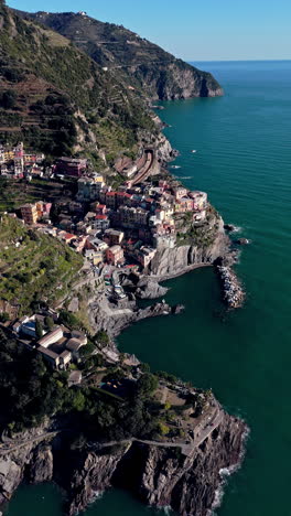 manarola village along the ligurian coast, showcasing colorful buildings and coastline, aerial view