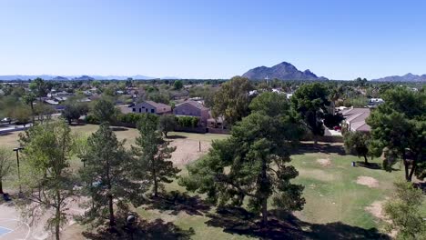 drone footage of scottsdale city park, tilt down from church cross to park