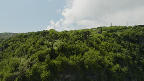 rusty material aerial tramway on wooded cliff in chiatura, georgia