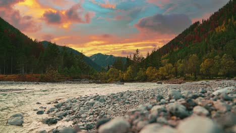 cinemagraph de 4k uhd: bucle de video continuo de un río de montaña en los alpes austríacos con un cielo nocturno vibrante, cerca de la frontera alemana en otoño