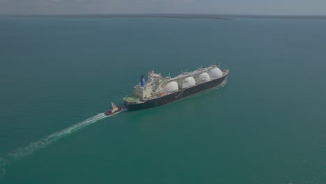 LNG-Gas-tanker-ship-underway,-accompanied-by-a-small-tug-boat