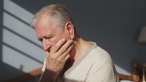 senior man lying on bed at home