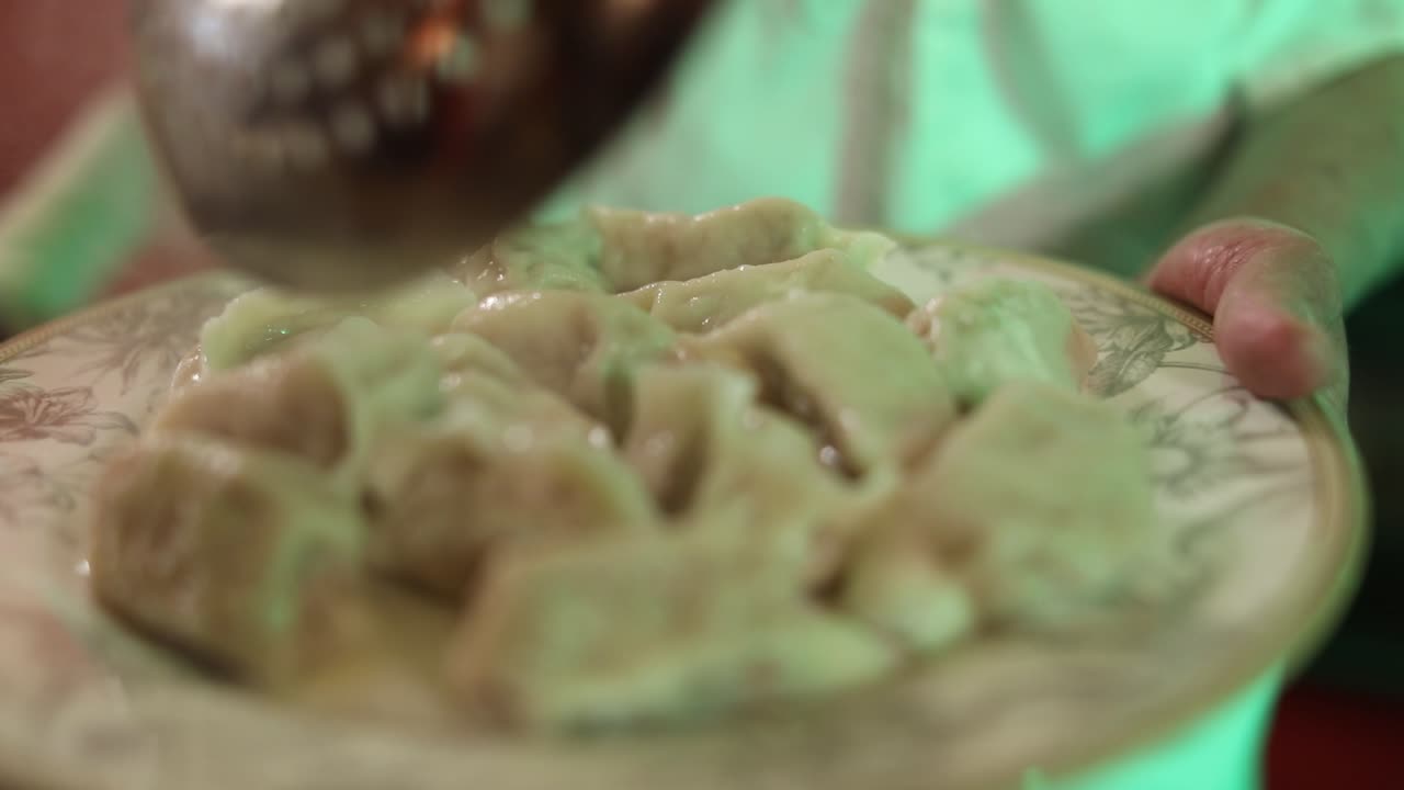 Primo piano di uno chef che impiattava ravioli appena bolliti