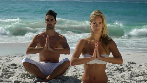 pareja haciendo yoga junto al agua