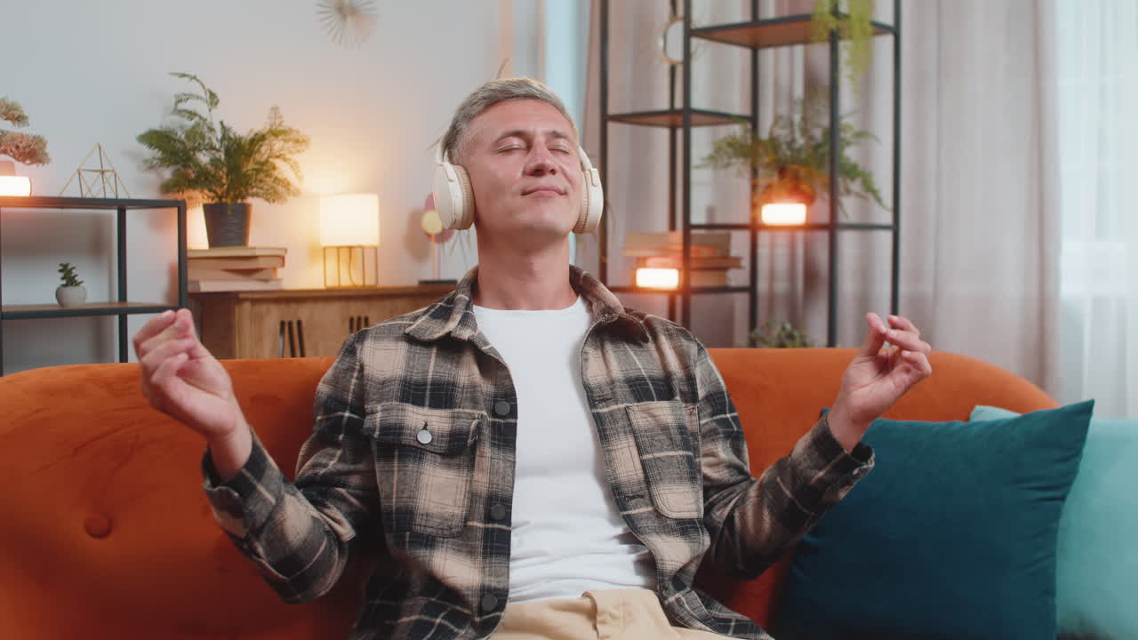 Man listening music breathes deeply meditating with concentrated thoughts peaceful at home room