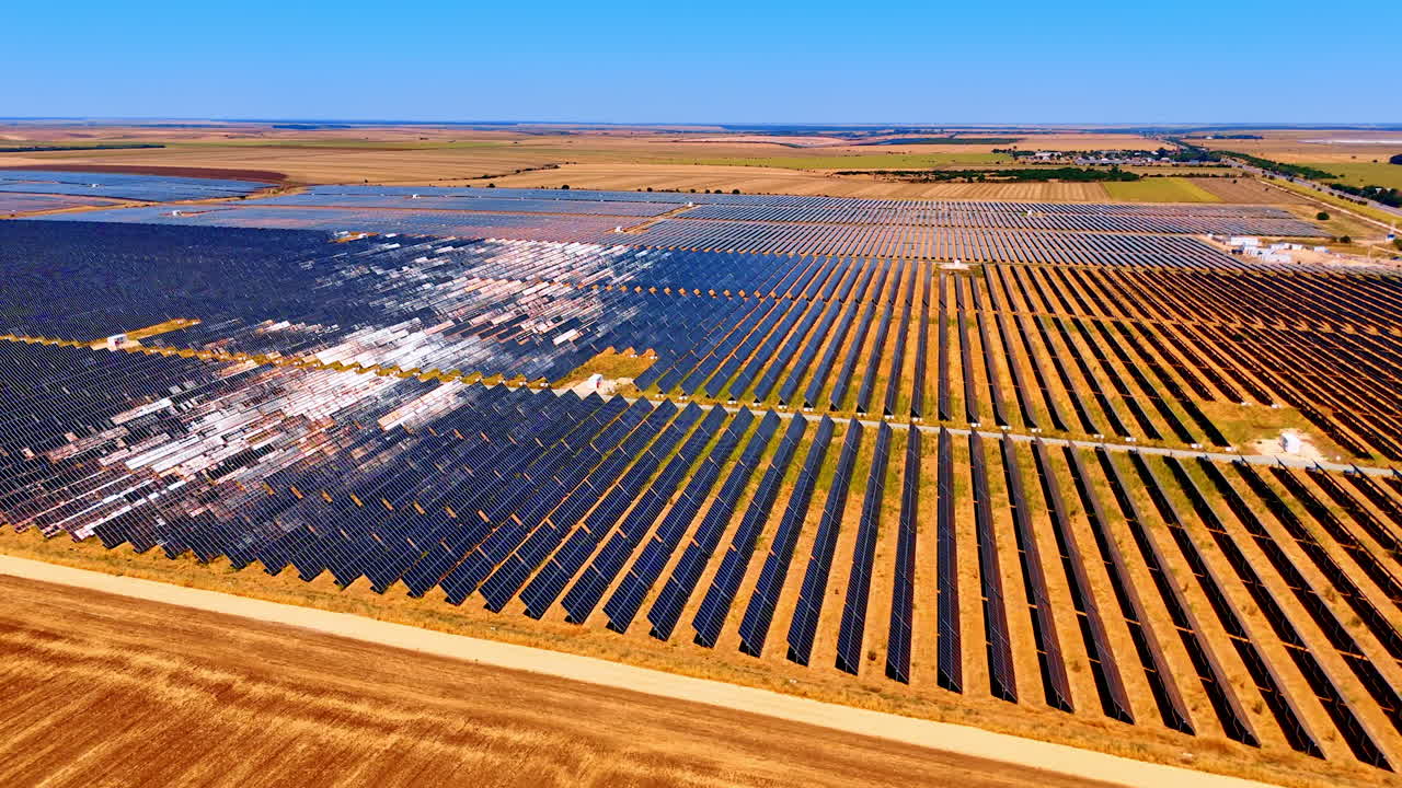 Mowed yellow fields with vast solar panels territories. Photovoltaic (PV) cells accumulate solar power. Aerial view