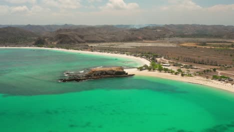 the white sand beach of tanjung aan in lombok, indonesia during a sunny day