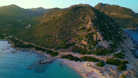 Paisaje-Al-Atardecer,-Gente-Disfrutando-De-La-Playa-Y-El-Fondo-De-Las-Montañas