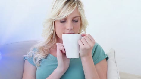 Animation-of-light-trails-over-caucasian-woman-holding-mug-and-drinking