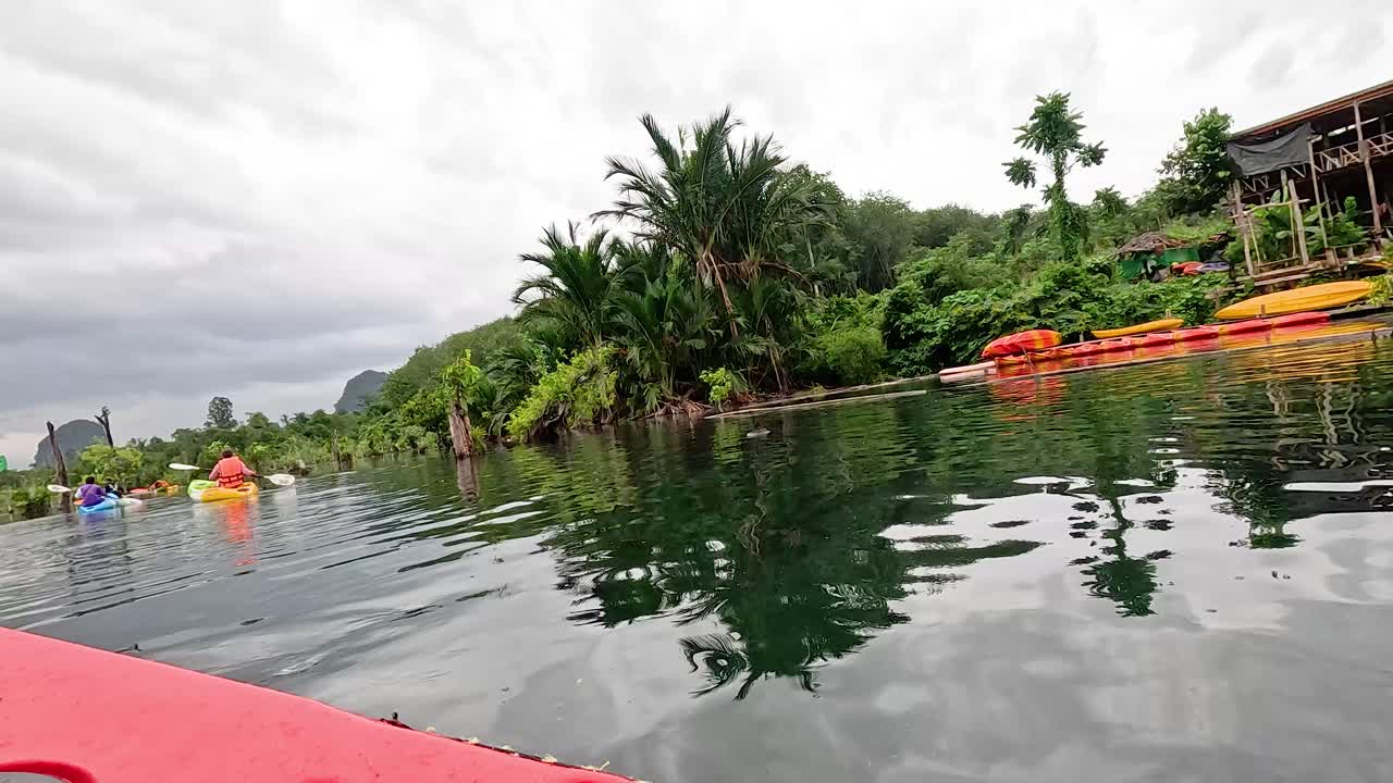 카야크 타는 사람 들 은 울창 하고 경치 좋은 수로 를 항해 한다