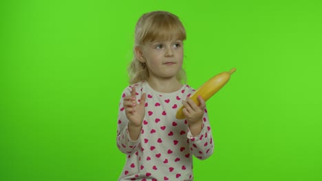 happy child girl kid imitating telephone conversation with banana isolated on chroma key background