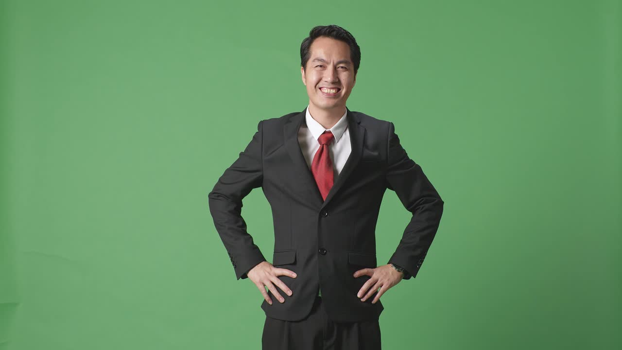 스튜디오의 녹색 스크린 배경에서 따뜻하게 미소 짓는 아시아 사업가