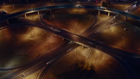 intersection circle transport junction at night city road with car traffic, aerial view from drone
