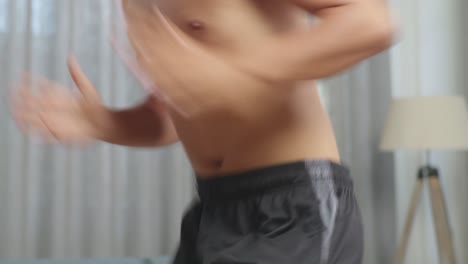 close up of asian teenager boy doing running in place during the shirtless workout at home