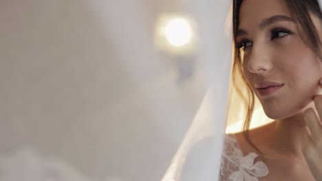 bride in boudoir dress under veil and in a silk robe. wedding morning preparations before ceremony