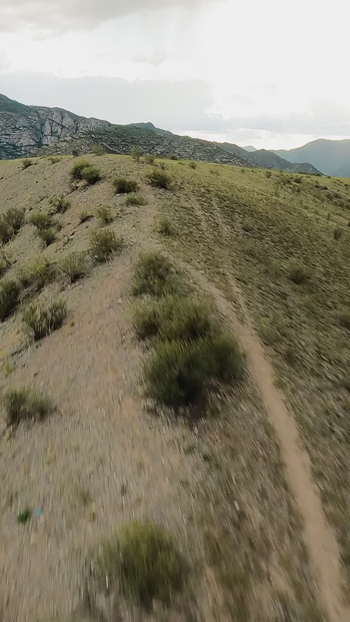 pistas de tierra en la cresta de la montaña en el valle del río fpv drone. los senderos encarnan el sentido de la aventura invitando a los exploradores a abrazar el desafío. terreno de las tierras altas