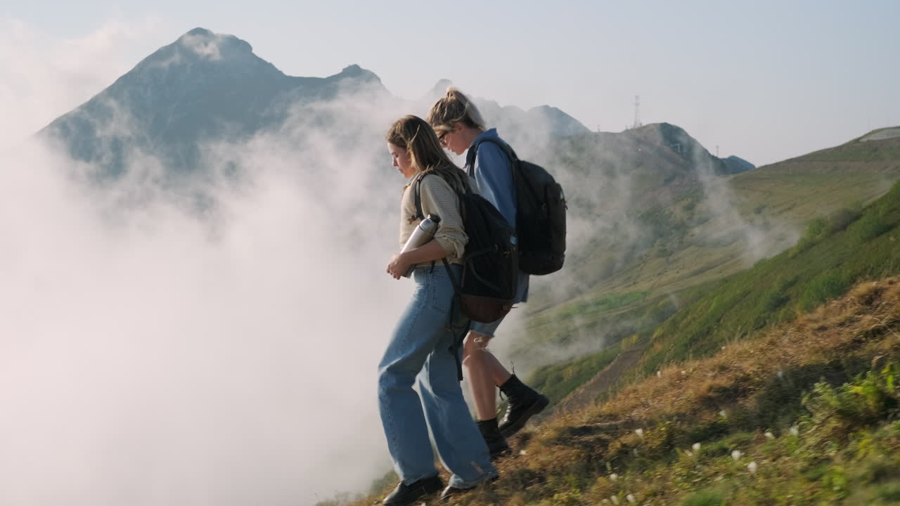 두 명의 여성이 구름 속에서 하이킹을 하고 있습니다.