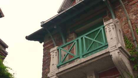 Beautiful-vintage-green-balcony-in-the-medieval-Montsouris-street,-Paris