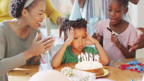 Feliz-Familia-Afroamericana-Celebrando-Cumpleaños,-Hijo-Soplando-Velas-En-El-Pastel,-Cámara-Lenta