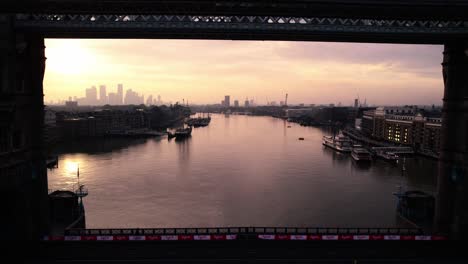 london, england uk at sunset, revealing cinematic aerial view of tower bridge, thames river and mist above cityscape skyline