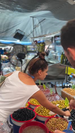 woman buying olives at a market