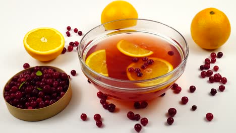 non - alcoholic fruit punch with fresh cranberries and orange in a glass bowl.