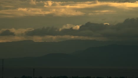 low clouds rolling over mountains on a scenic sunset