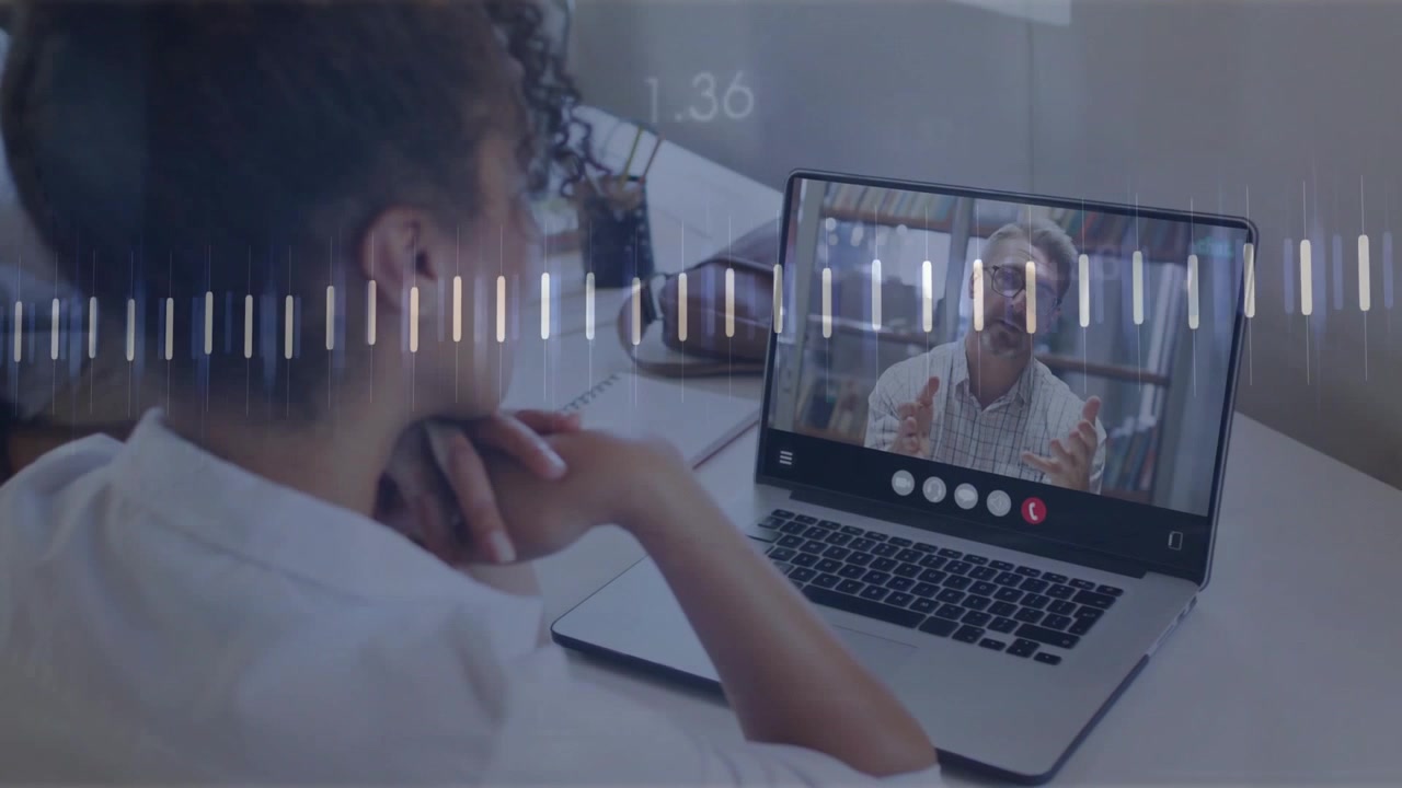 Mann på avstand snakker og gestikulerer, mens middelaldrende kvinne ser på, med søyler som stiger og viser livedata under samtale.