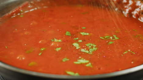 chicken in tomato sauce is boiling on a frying pan with spices. cooking tomato sauce curry with chicken fillet. traditional italian mexican asian dish. high quality studio shot for cafe, restaurant close up.