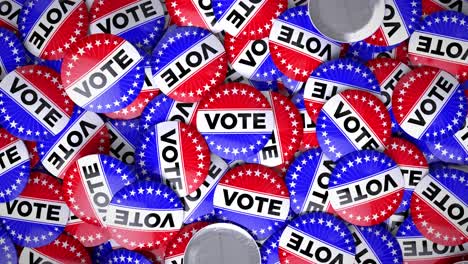 patriotic usa election vote buttons in a pile.  pins feature stars and stripes theme in red white and blue.