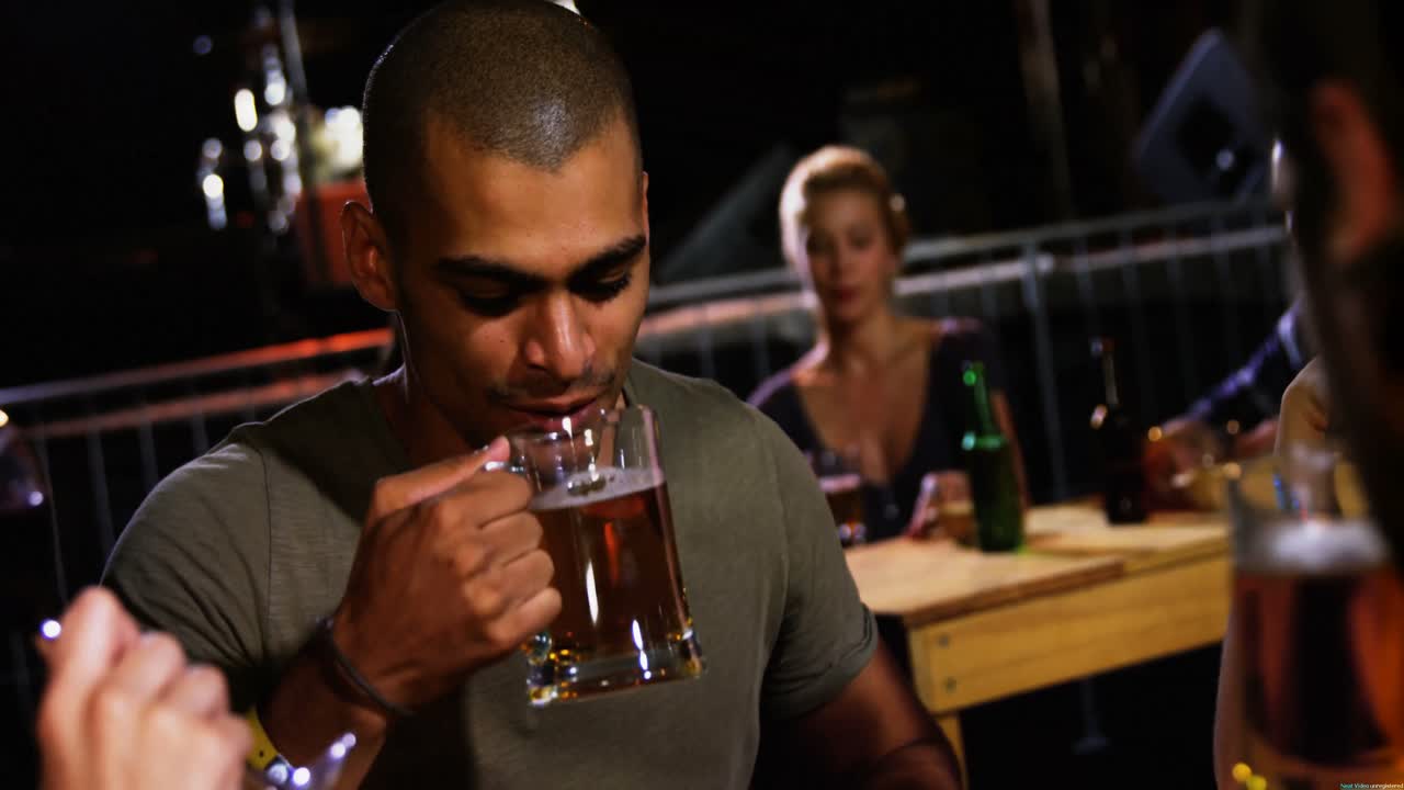grupo de amigos brindando tazas de cerveza en un concierto 4k