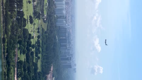 impresionantes imágenes aéreas capturan un enorme avión descendiendo hacia el aeropuerto de singapur, enmarcado por las arenas de la bahía de marina, con los rascacielos de la ciudad y los exuberantes jardines en el fondo