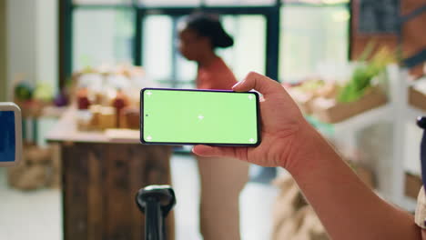 el vendedor muestra una pantalla verde en el teléfono