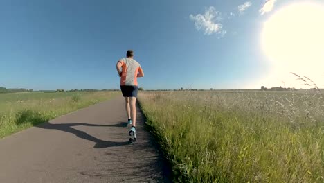 Funky-camera-immersive-swirling-movement-with-changing-angles-and-perspective-showing-a-male-trail-runner-on-floodplains-valley-dyke