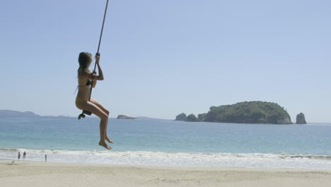 Mädchen-Auf-Seilschaukel-Am-Strand-Von-Hahei,-Neuseeland