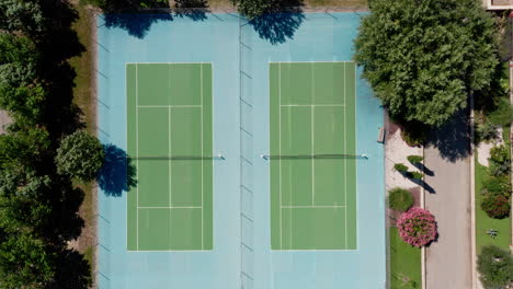 empty tennis courts aerial top shot green and blue court france