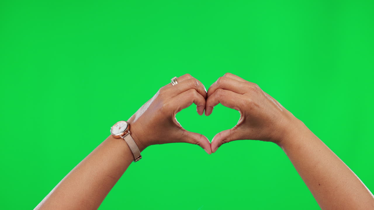 el corazón, el amor y las manos de la mujer en la pantalla verde