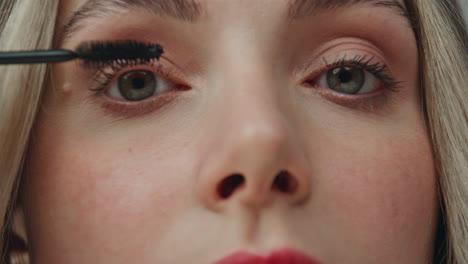woman applying mascara on her eyelashes