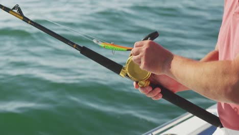 side view mid section of a caucasian man fishing on a boat