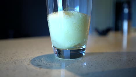 vertiendo agua en un vaso alto con crema