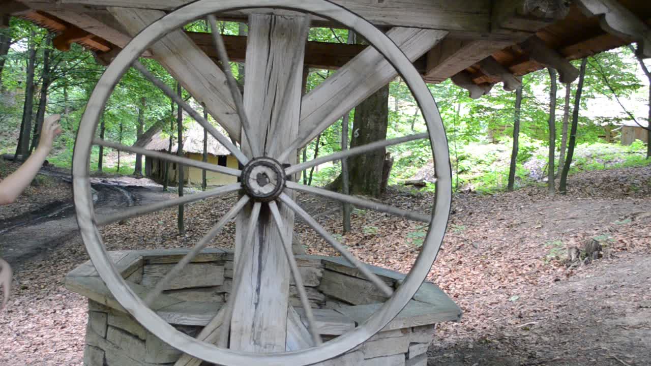 Ancient well. The wheel turns and the bucket with water rises. Lviv, Ukraine