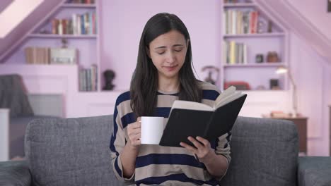 Niña-India-Cansada-Leyendo-Un-Libro-Y-Tomando-Café