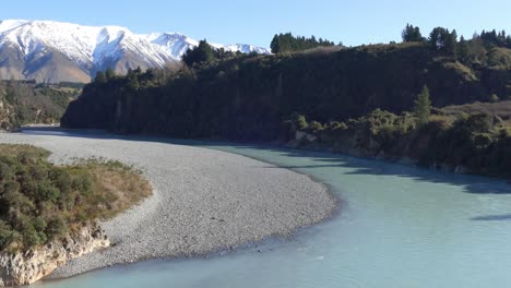 glacier-fed river curves through landscape with foothills of the southern alps in background - rakaia river gorge, new zealand