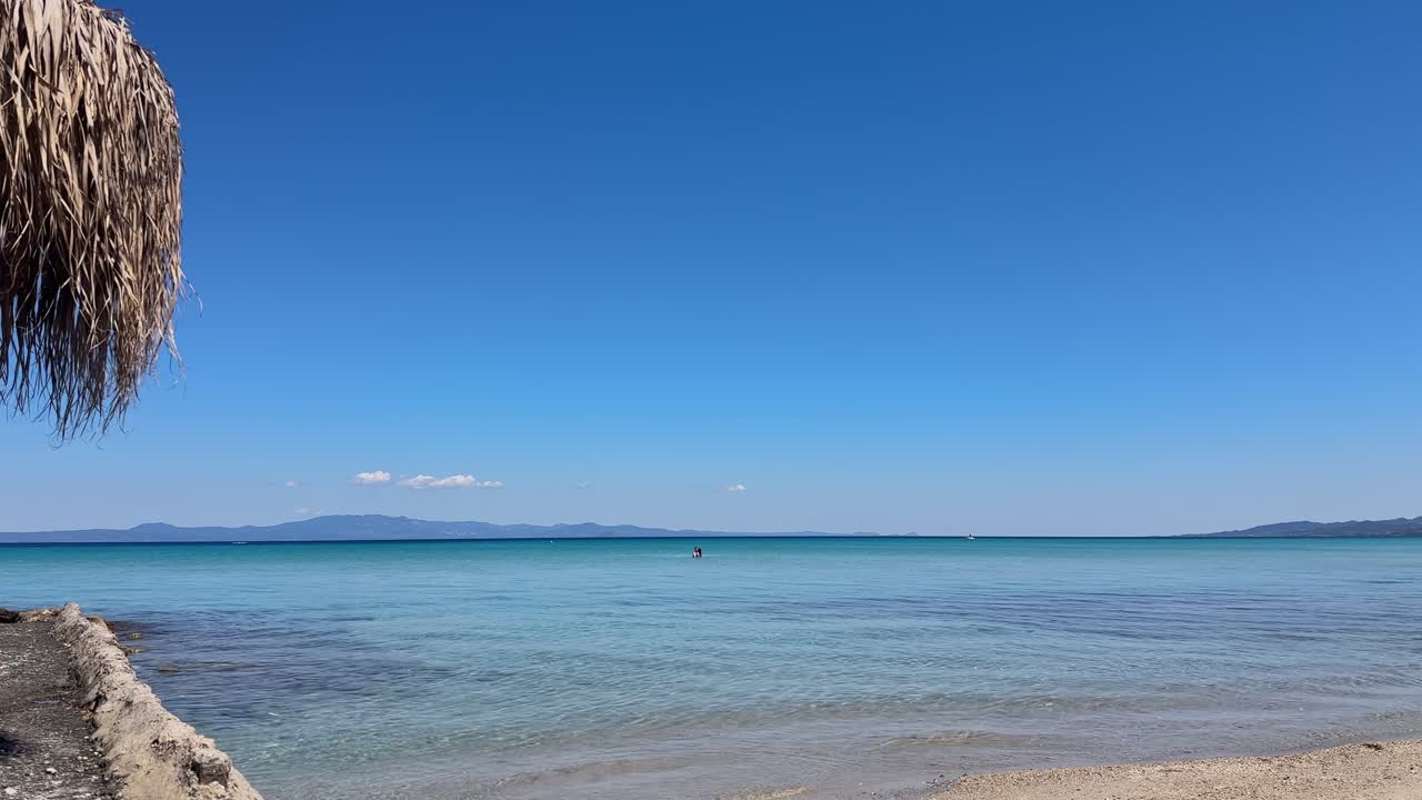 Stunning beach scene in Halkidiki, Greece, with elegant sunbeds facing the crystal-clear turquoise sea. A perfect summer escape in the heart of the Aegean.