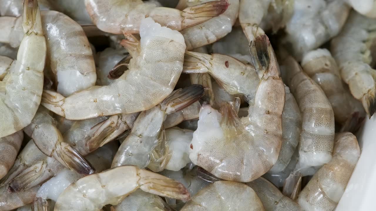 많은 원시 새우가 큰 그에 놓여 있습니다.