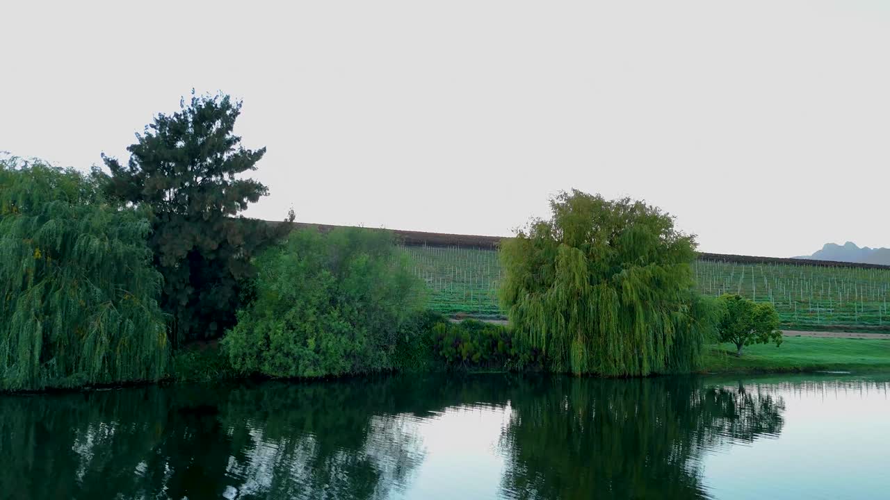 Sweeping 4K drone view of a picturesque lake with luscious green hills