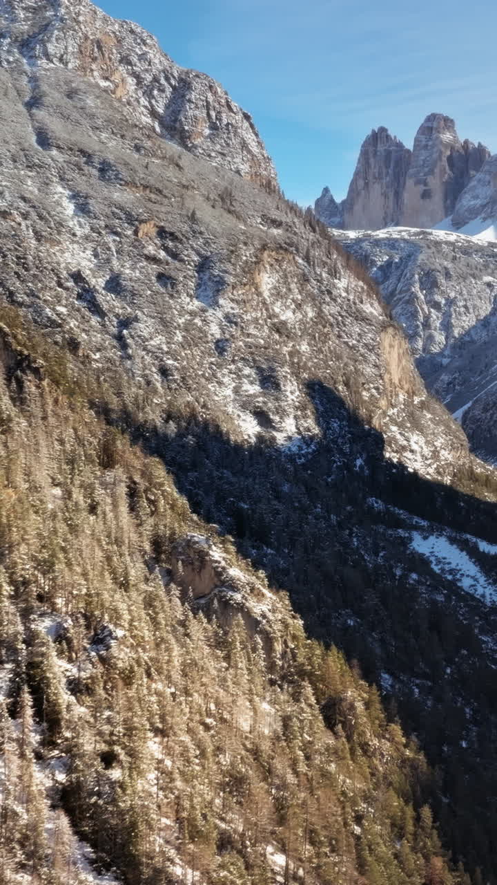 Aerial drone view of the Tre Cime di Lavaredo in the Sexten Dolomites of northeastern Italy with the blue sky on the background. Vertical