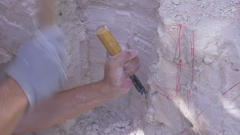 man with hammer and chisel hits a soft rock